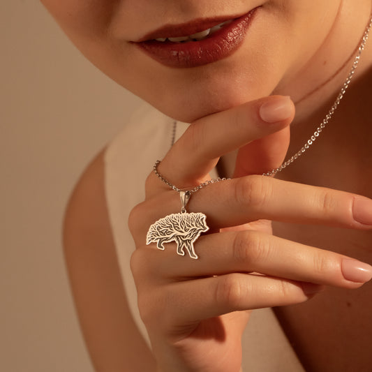Detailed wild boar pendant with botanical tree design