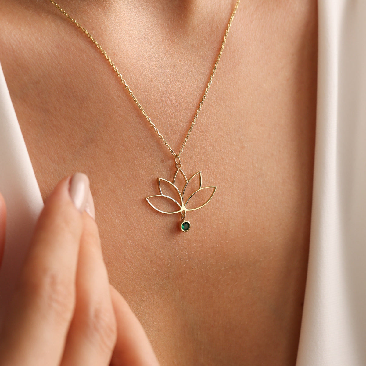 Lotus necklace shown in hand