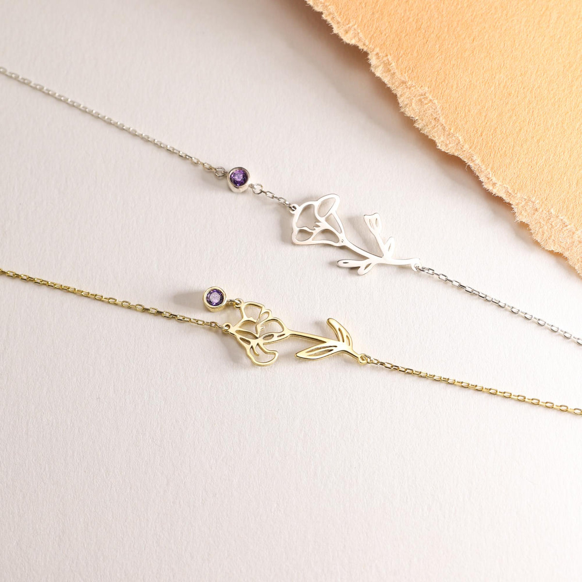 Birth flower bracelets in silver and gold laid flat