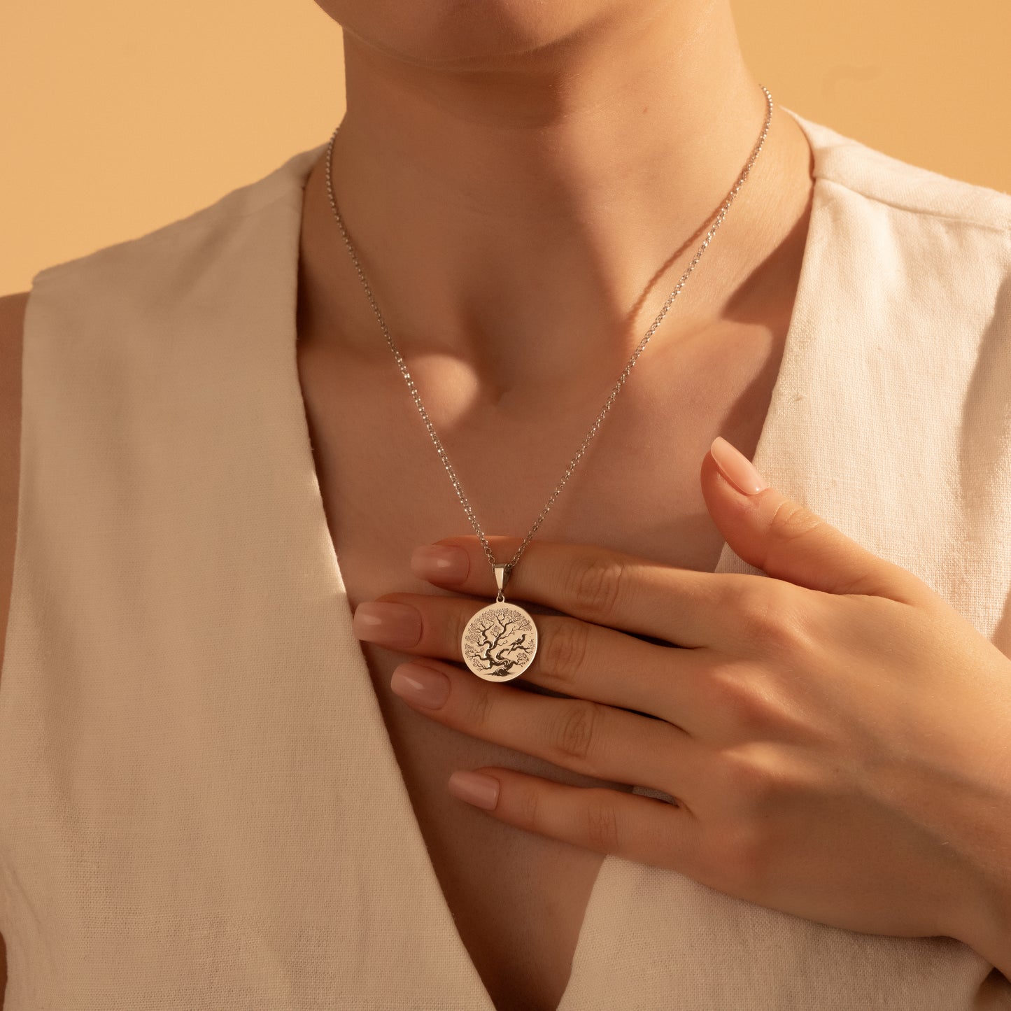 Silver Tree of Life coin necklace worn by a woman