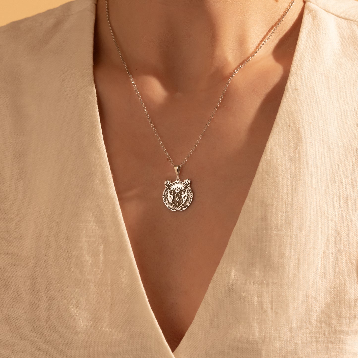 Detailed silver deer medallion necklace close-up