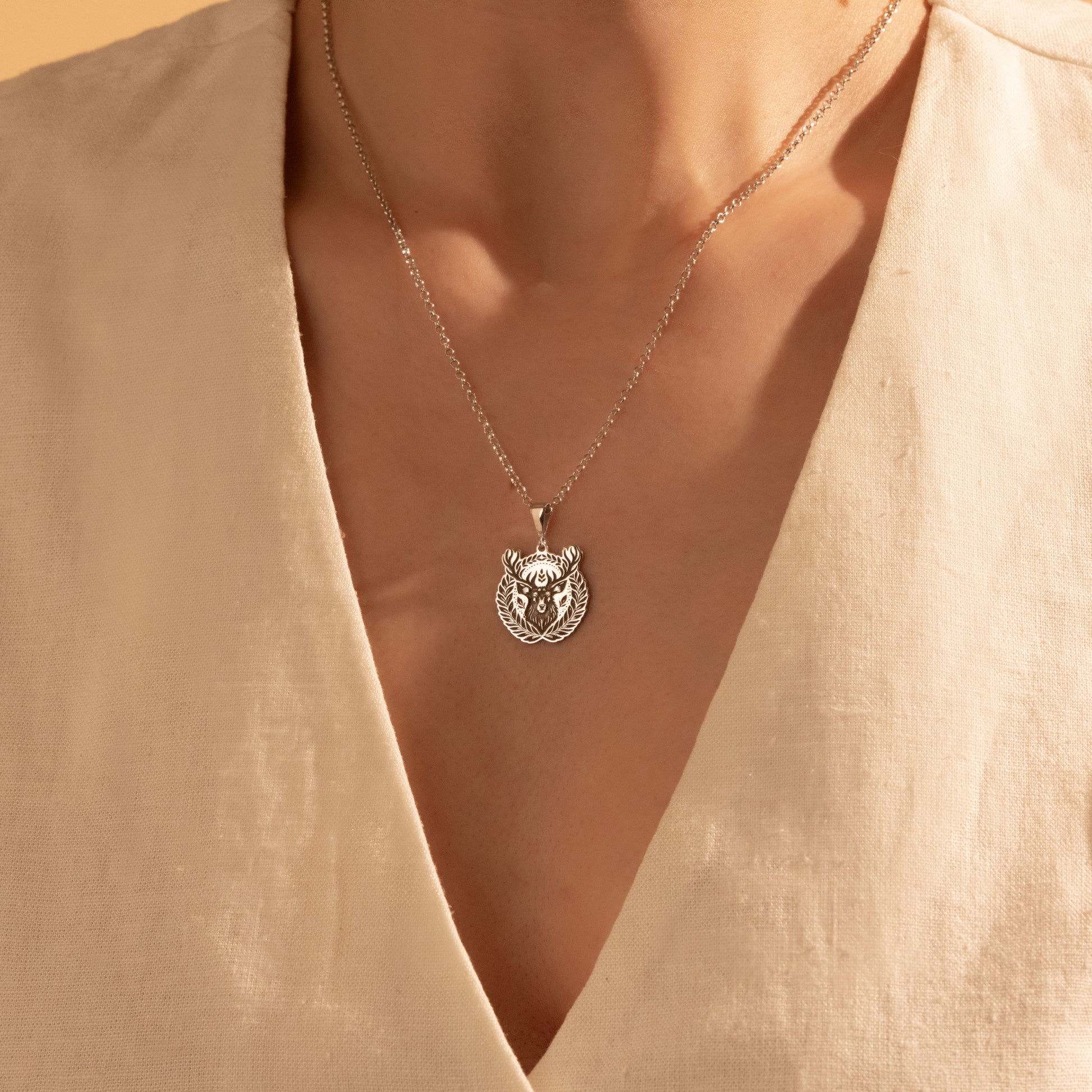Detailed silver deer medallion necklace close-up