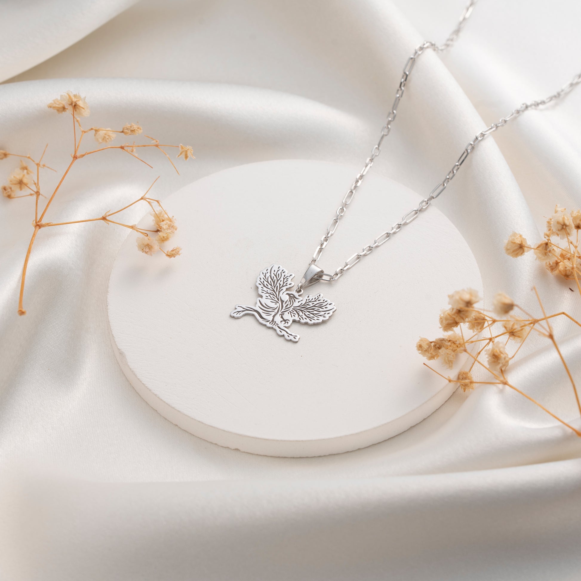 Detailed silver eagle pendant with botanical tree design