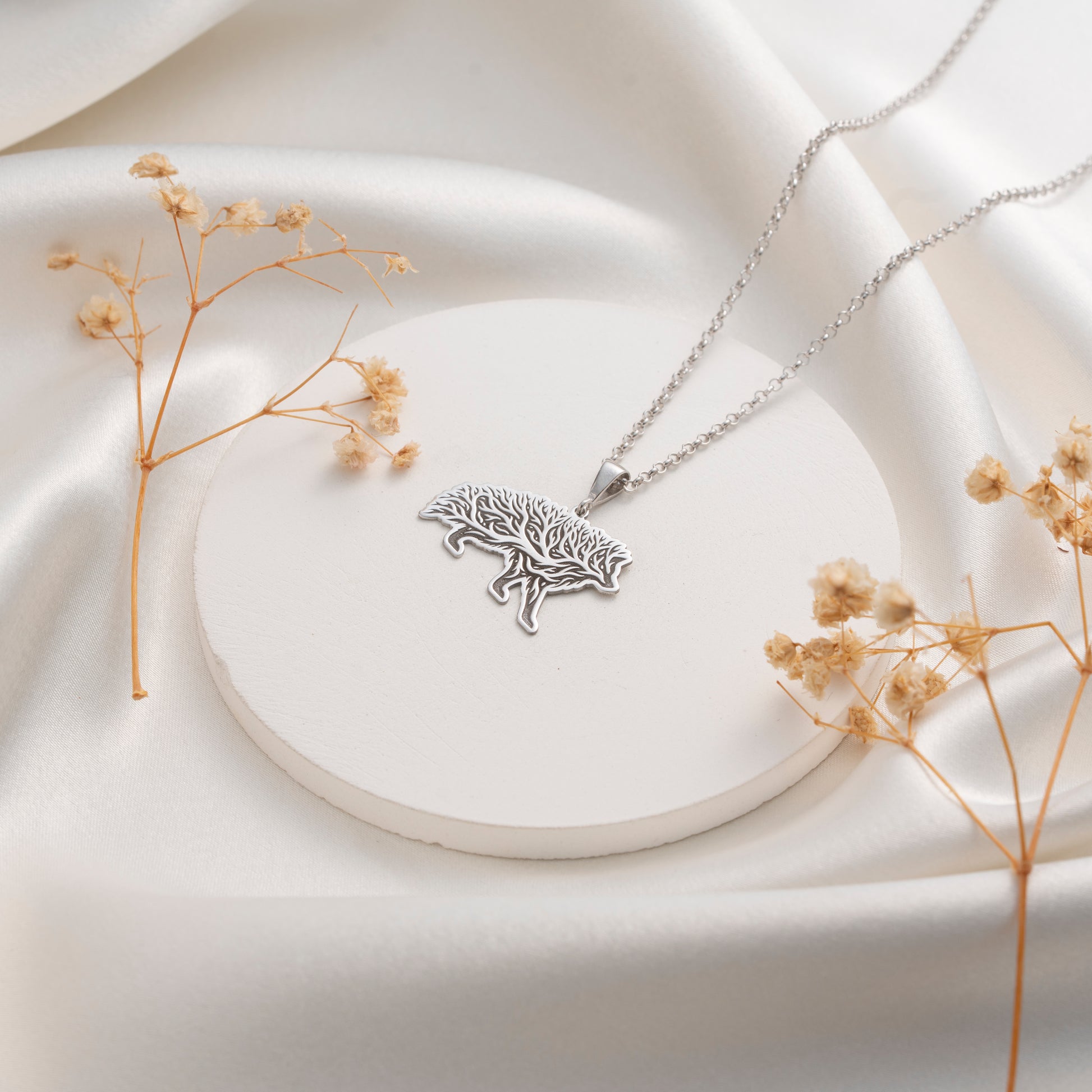 Detailed wild boar pendant with botanical tree design