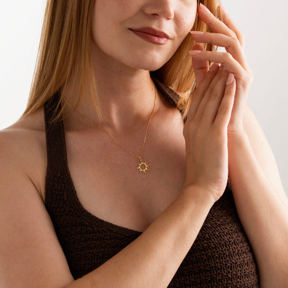 Sun pendant necklace worn on the neck, close-up of the engraved sun rays