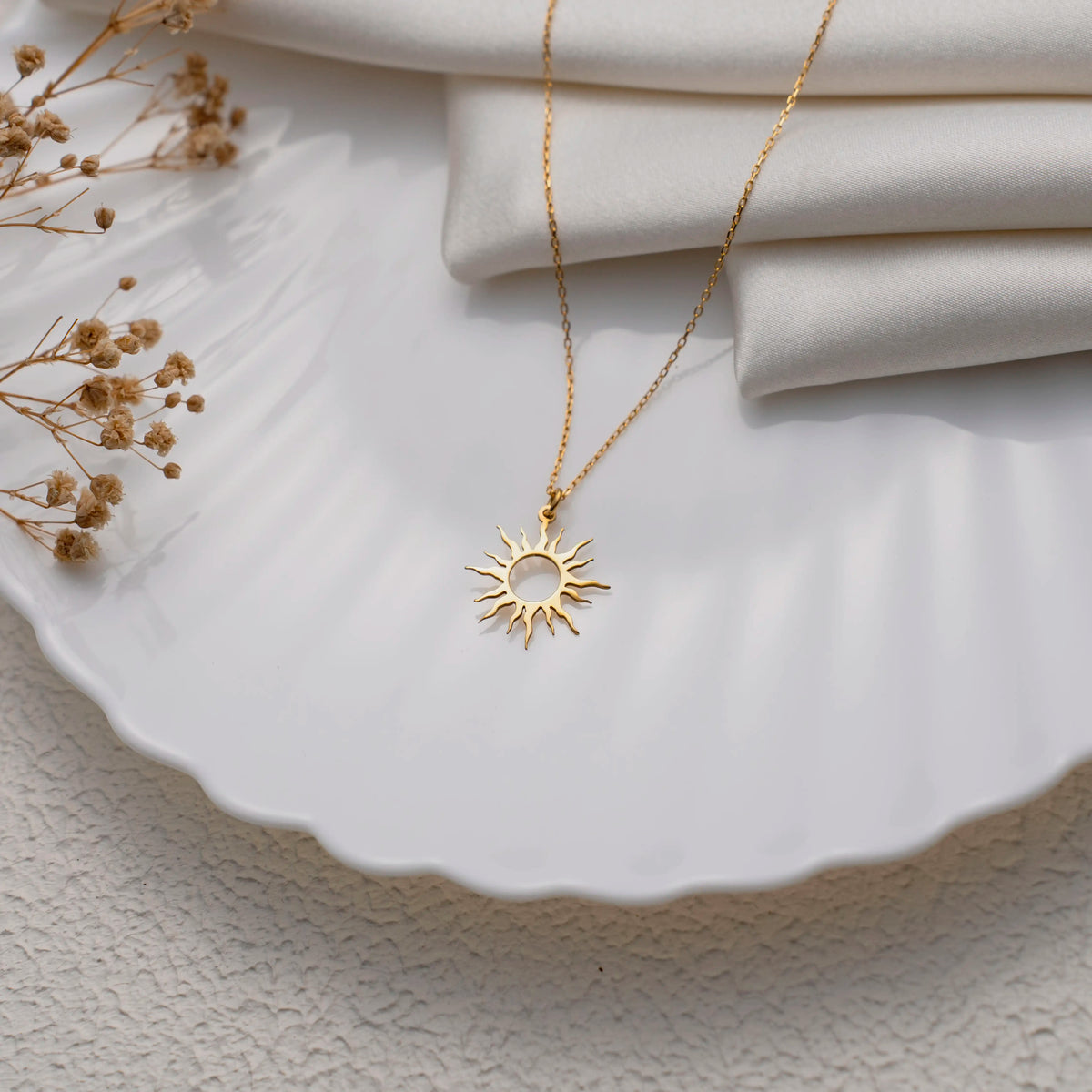 Sun necklace flat lay showing the fine cable chain and clasp