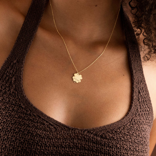 Gold personalized clover initial necklace worn by model