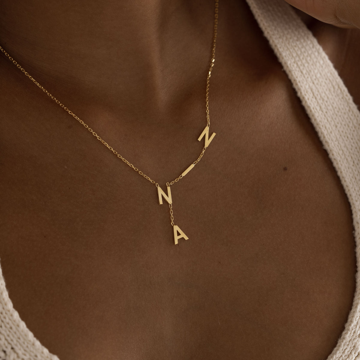 Custom initial pendants arranged along necklace chain