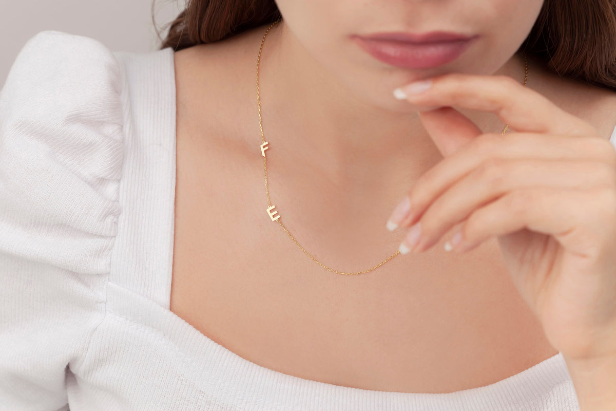 Dainty sideways initial pendant on the neck