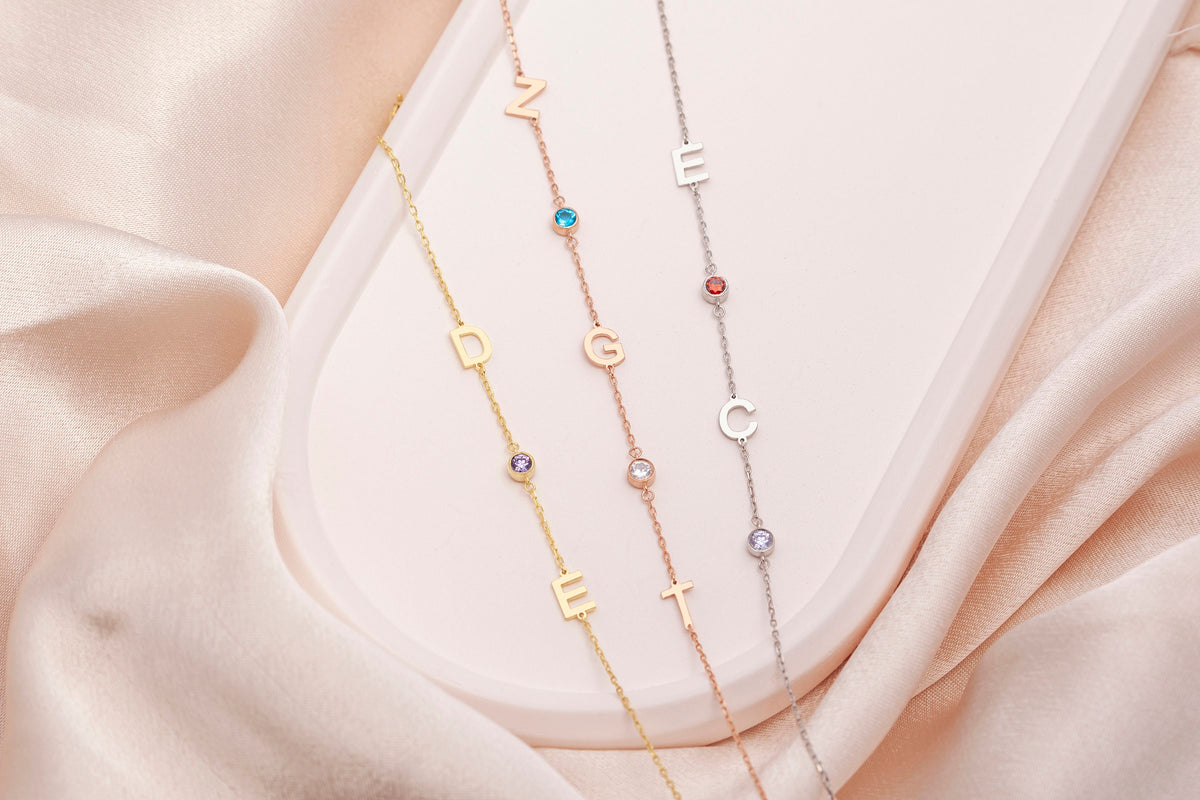 Sideways letter necklaces laid flat
