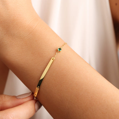 Engraved bar bracelet in gold with a birthstone on the wrist