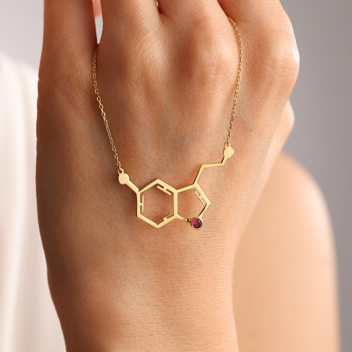 Serotonin necklace laid flat with a birthstone