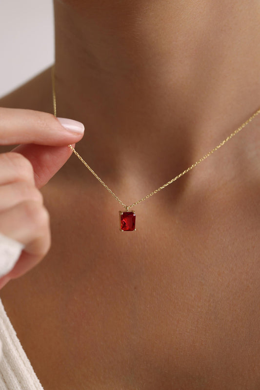 Emerald cut red birthstone necklace worn on the neck