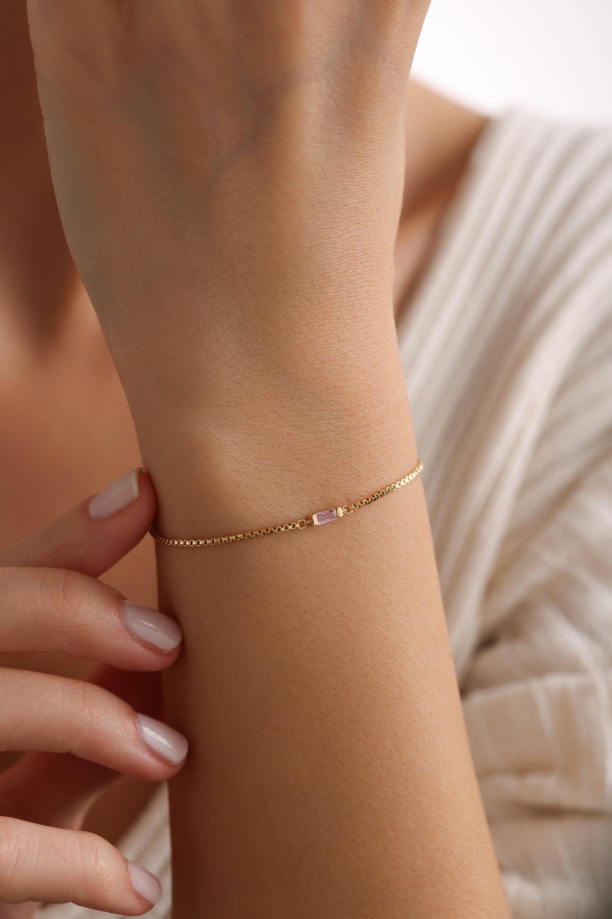 Baguette birthstone bracelet in gold worn on the wrist