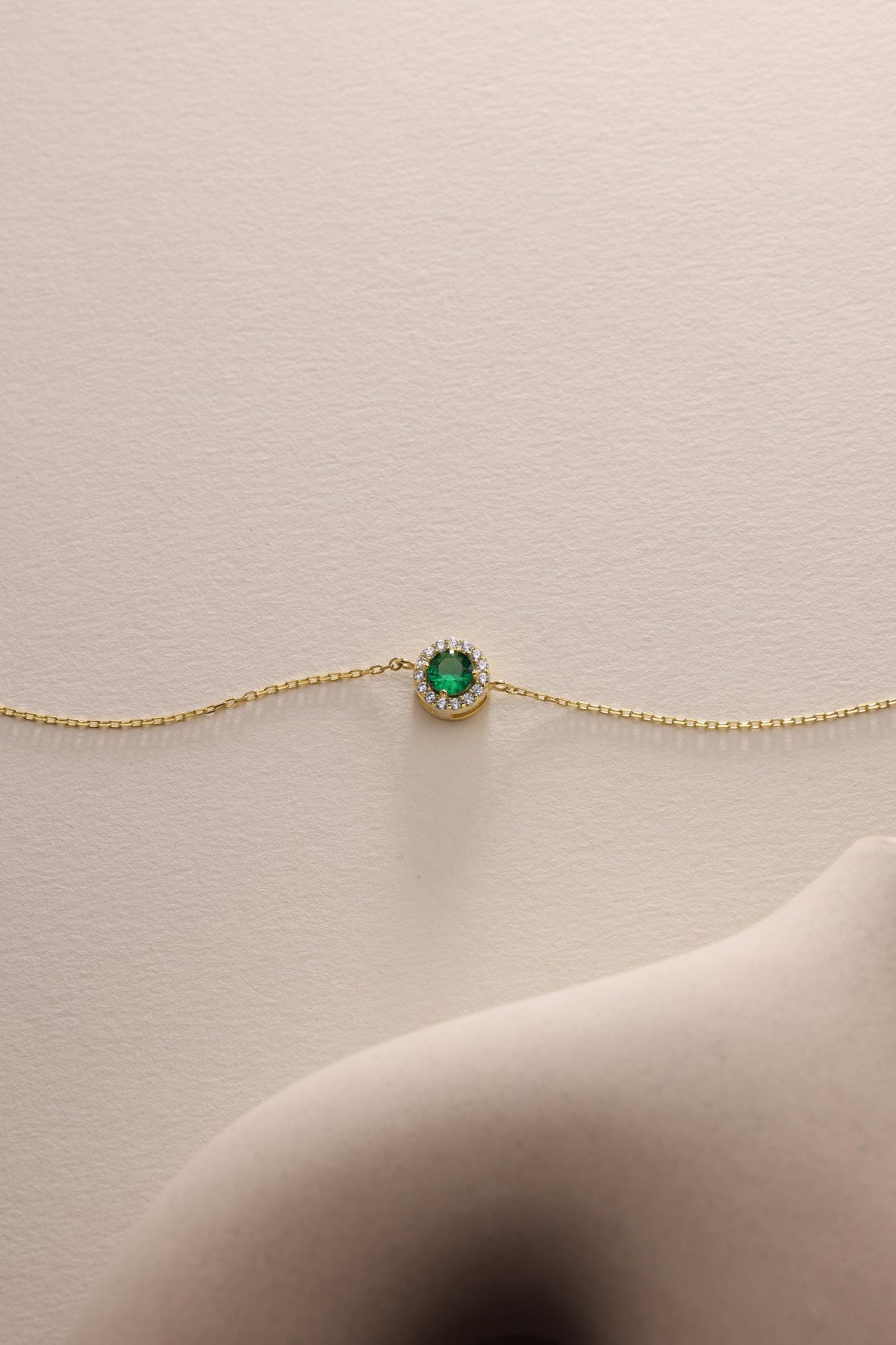 Emerald bracelet laid flat on a pale surface