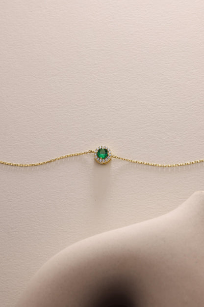 Emerald bracelet laid flat on a pale surface