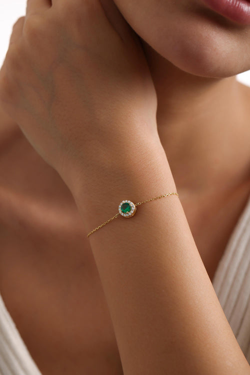 Emerald green stone bracelet in gold on the wrist