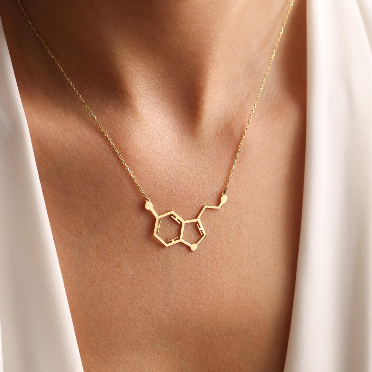 Molecule necklace shown in hand