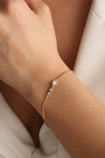 Custom birthstone bracelet in gold worn on the wrist
