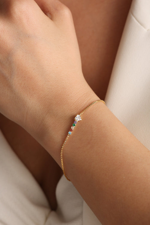 Custom birthstone bracelet in gold worn on the wrist