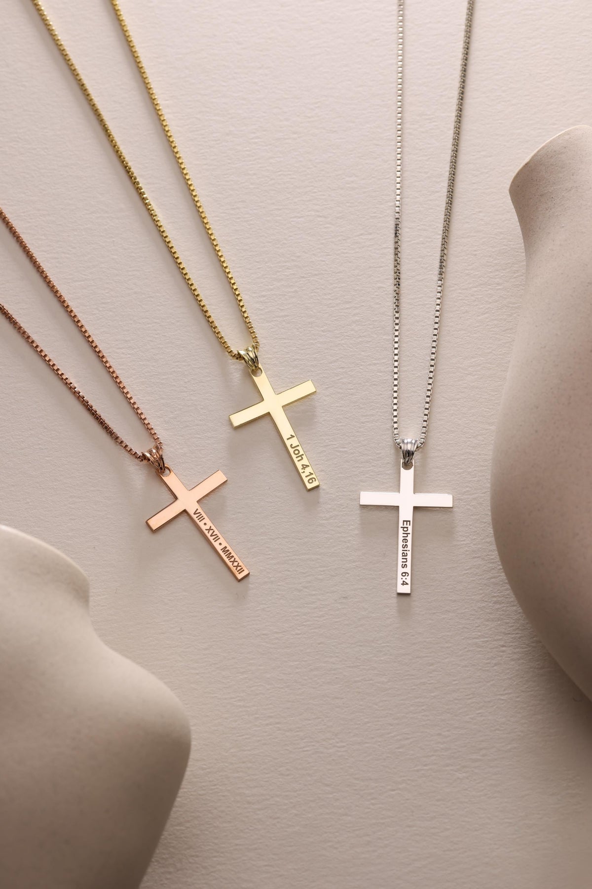 Cross necklaces in three finishes laid flat