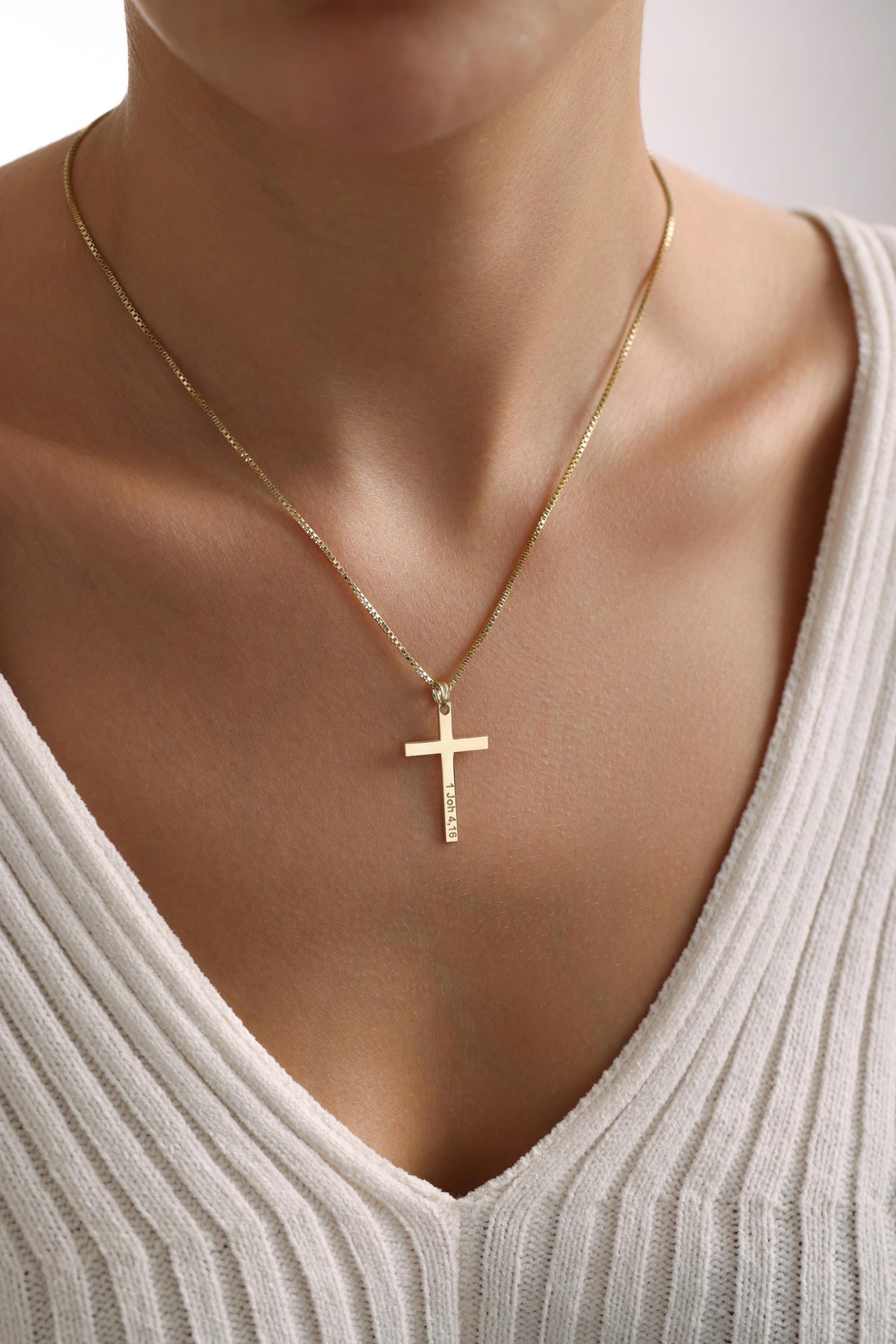 Cubic zirconia cross pendant worn close up