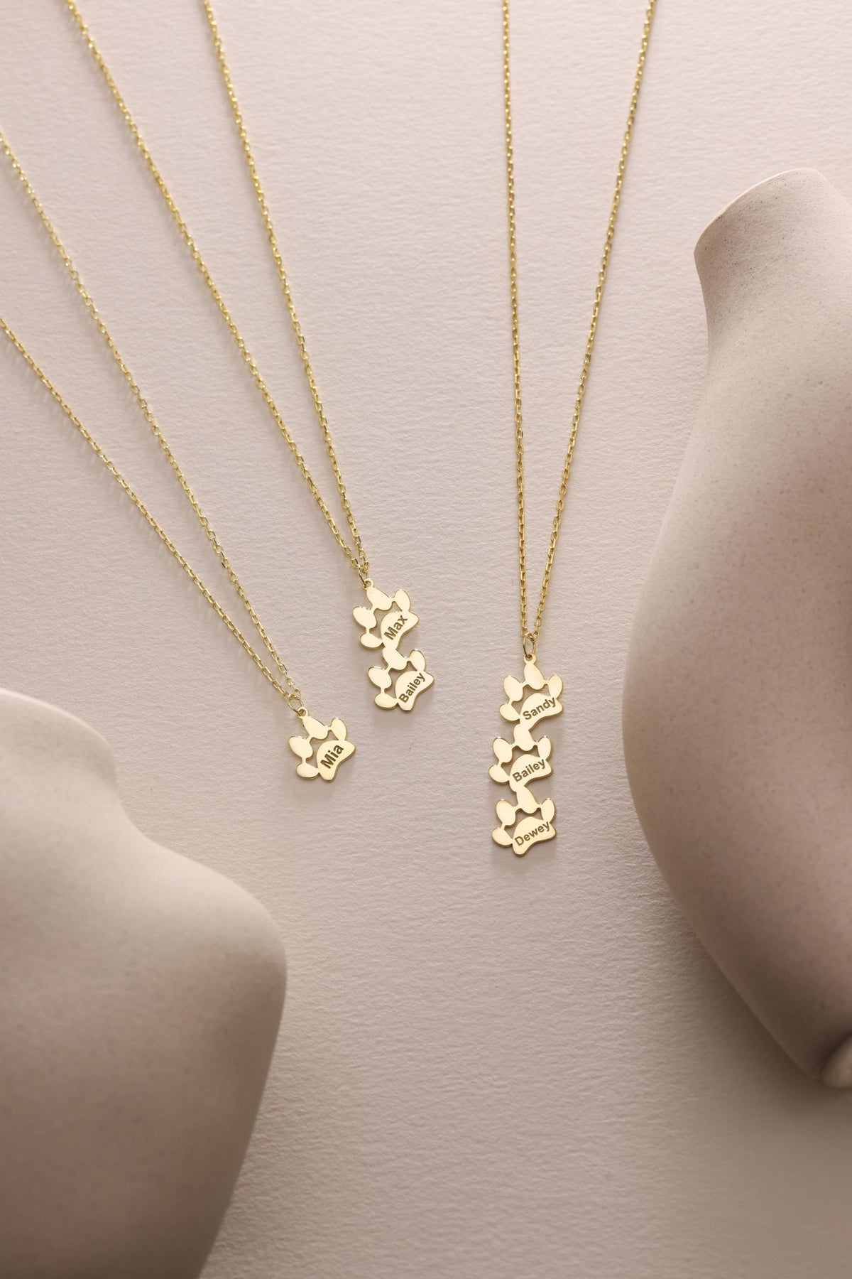Engraved paw print necklaces in two finishes side by side