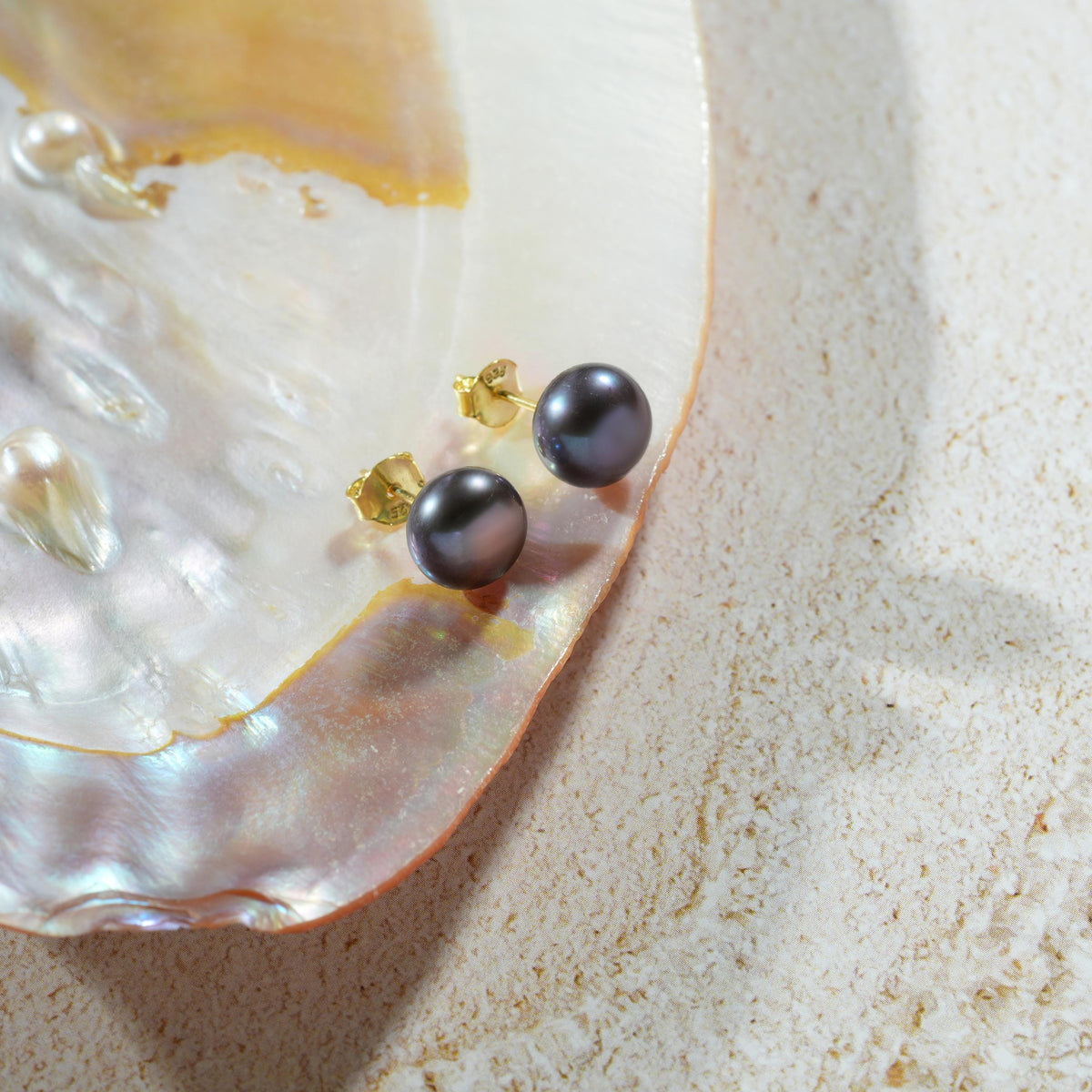 Black pearl stud earrings in gold finish