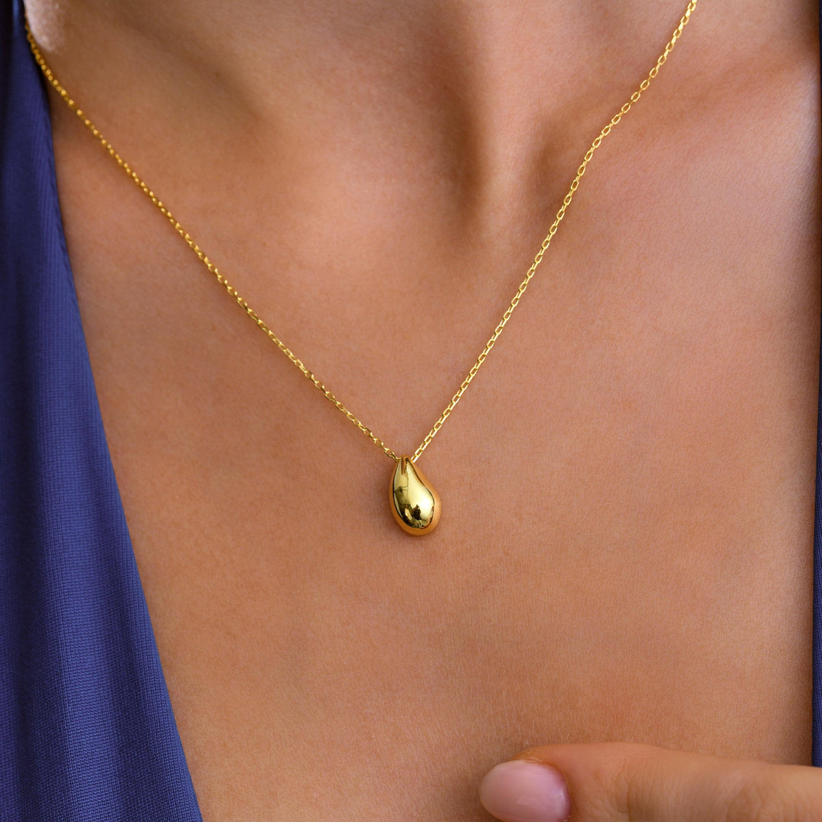 Polished teardrop necklace styled with foliage