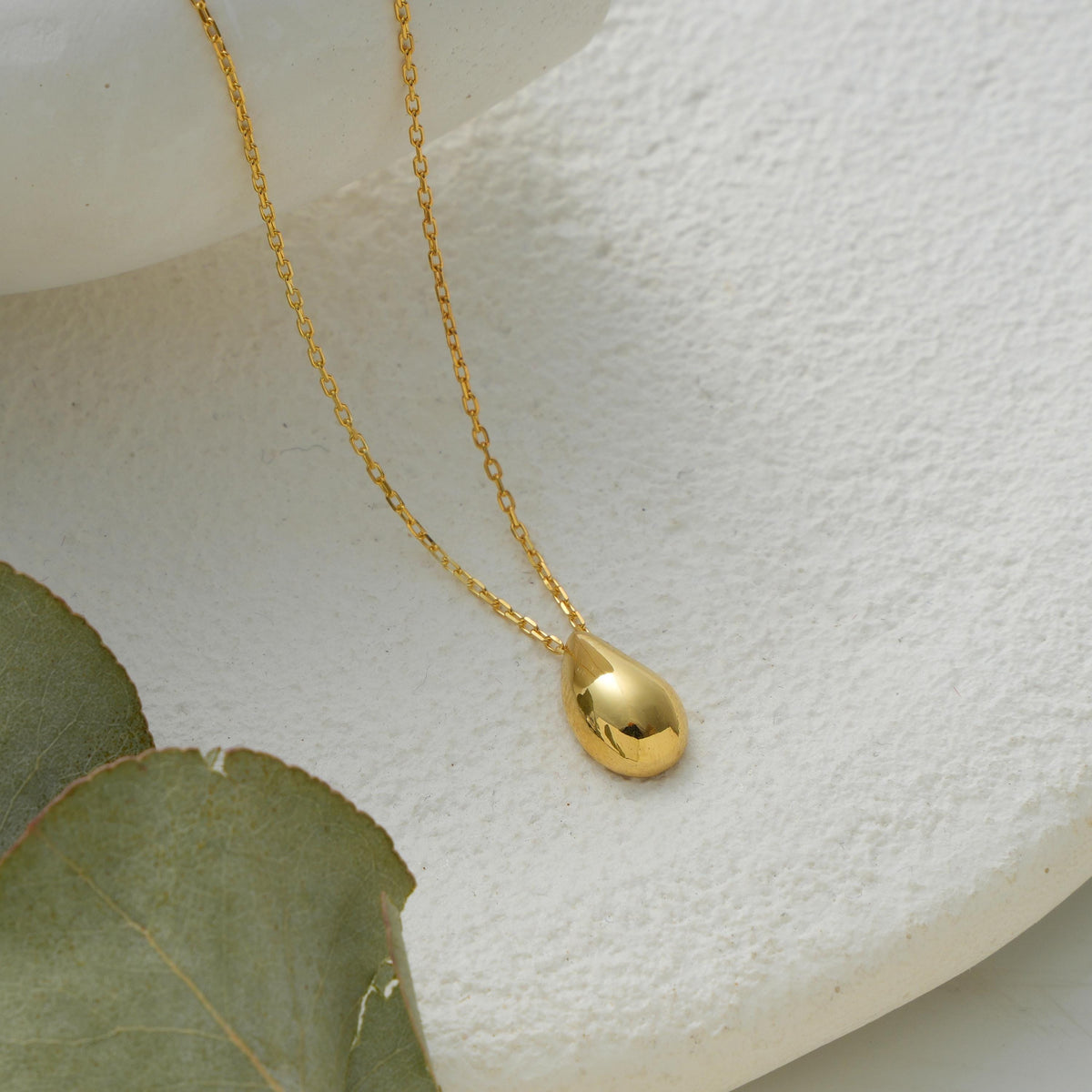 Smooth drop pendant necklace laid flat