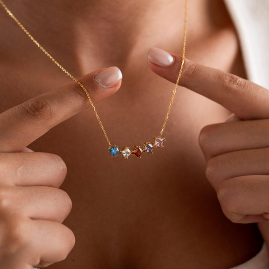 Birthstone bar necklace held up by a woman