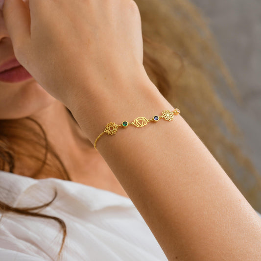 Chakra bracelet in gold with seven coloured stones on the wrist