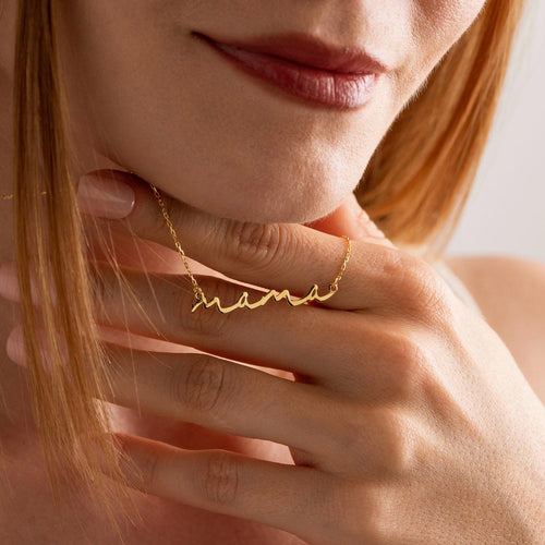 Script mama necklace held up by a woman