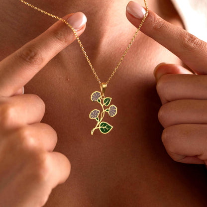 Purple enamel flower necklace held up by a woman