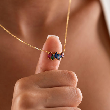 Marquise birthstone necklace held up by a woman