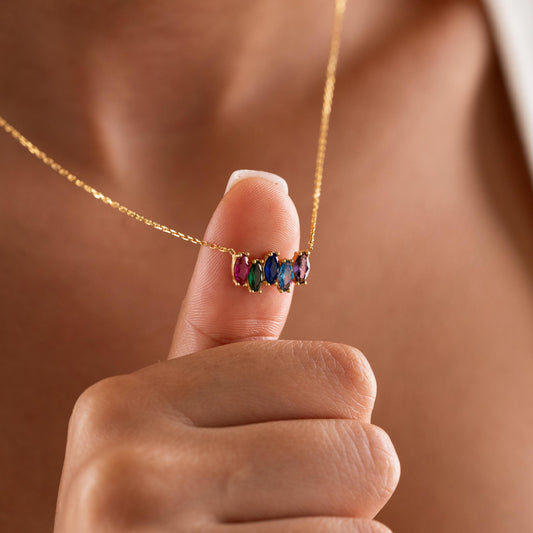 Marquise birthstone necklace held up by a woman
