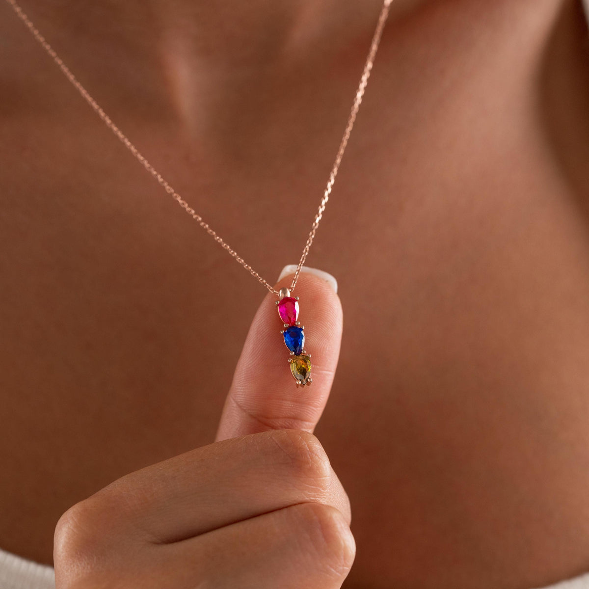 Teardrop birthstone necklace held up by a woman