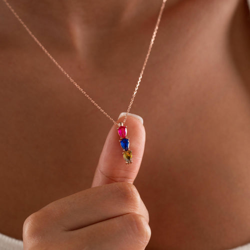 Teardrop birthstone necklace held up by a woman