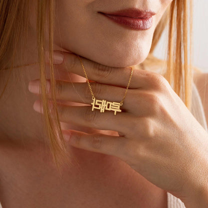 Korean Hangul name necklace held up by a woman