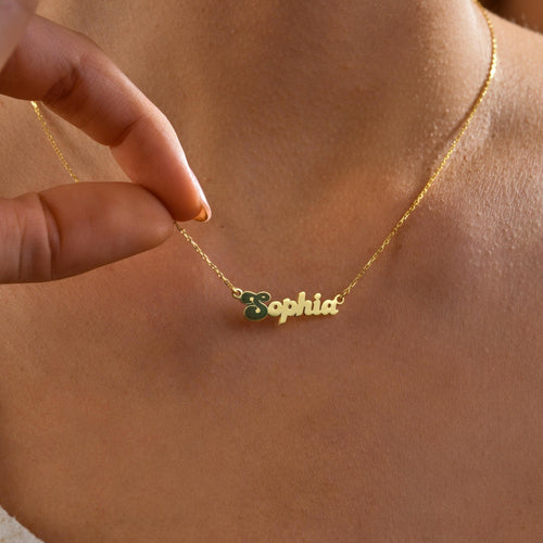 Name necklace with an enamel initial charm worn on the neck