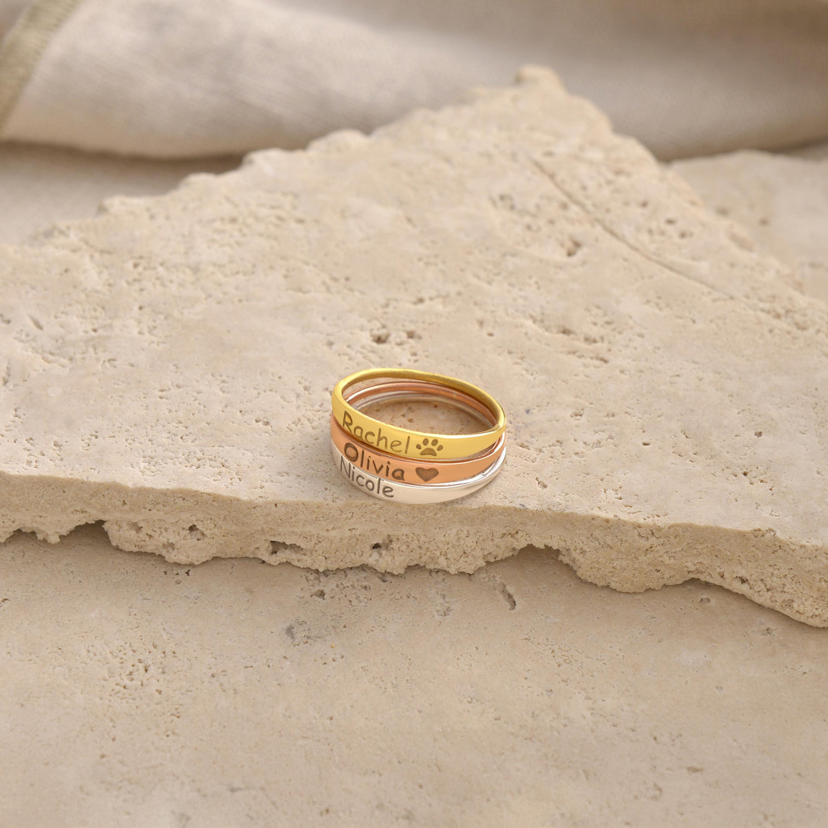 Engraved script name ring shown on a stone surface