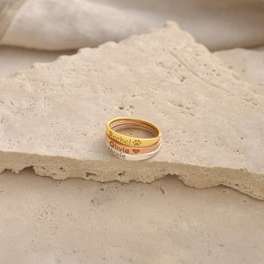 Engraved script name ring shown on a stone surface