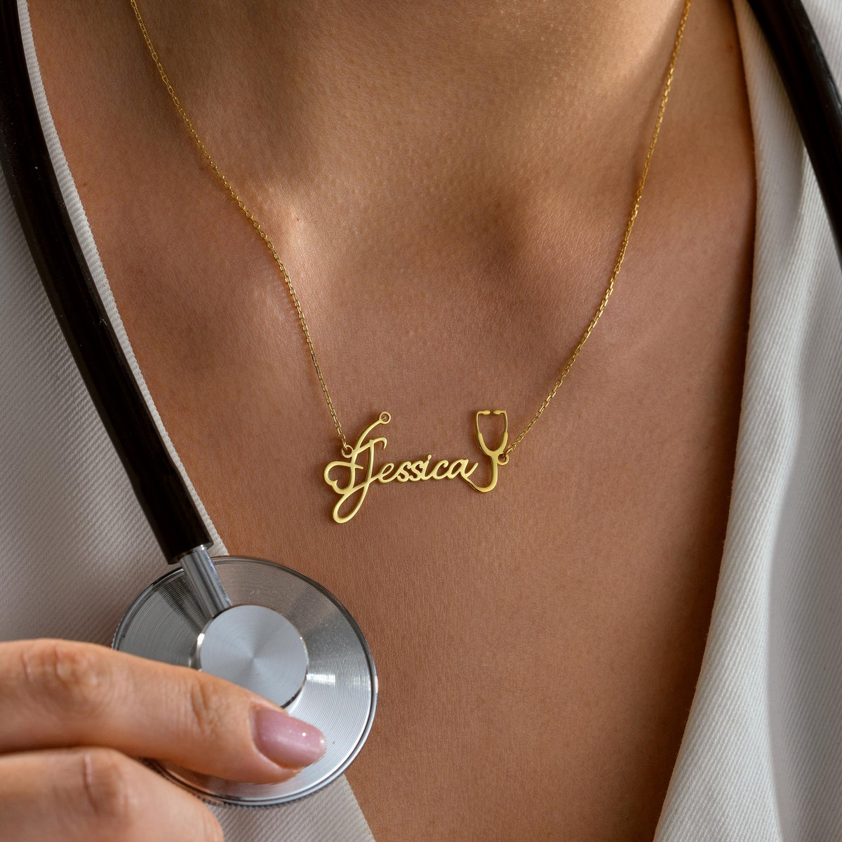 Stethoscope name necklace held up by a woman