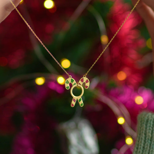 Candy cane Christmas necklace held up by a woman