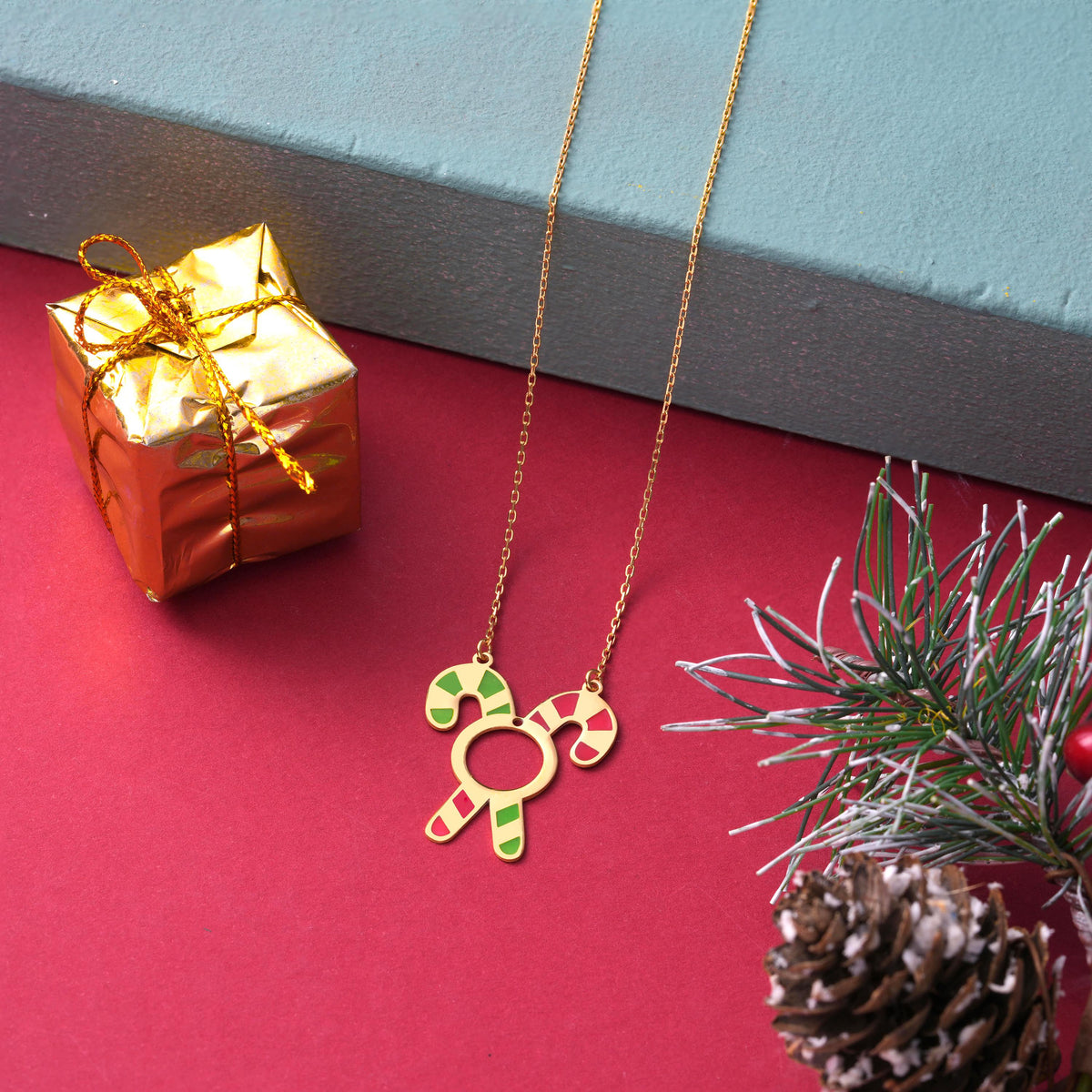 Red and green enamel candy cane pendant with a bow