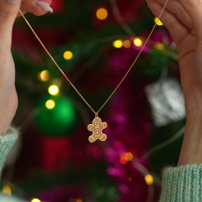 Personalized gingerbread man necklace held up by a woman