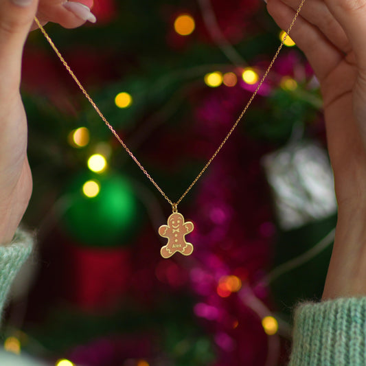 Personalized gingerbread man necklace held up by a woman
