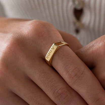 Personalized 18K gold plated engraved bar ring worn on a woman's finger