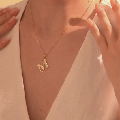 Gold letter M pendant necklace with openwork detailing