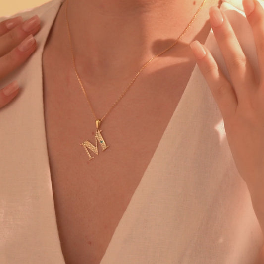 Gold letter M pendant necklace with openwork detailing